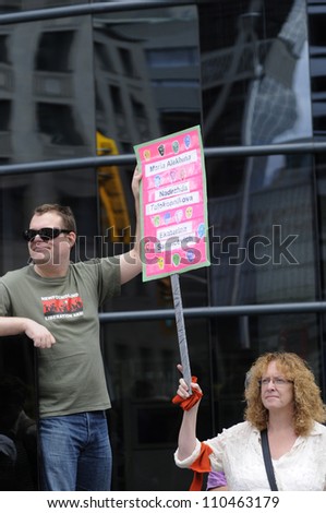 TORONTO -AUGUST  17:  A couple holding banners during a protest rally organized to free \