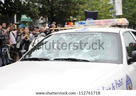 TORONTO-JUNE 26:   A vandalized police car lies on the street while citizens takes pictures  during the G20 Protest on June 26 2010 in Toronto, Canada.