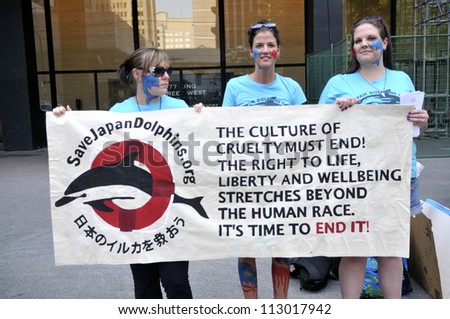 TORONTO-AUGUST 31: Protesters holding a sign to denounce the killing  of dolphins during a rally to protest the start of the annual dolphin hunt at Taiji,Japan on August 31,2012 in Toronto,Canada.