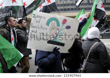 TORONTO-MARCH 16: Syrians walking in a rally with banners during a protest rally organized to raise awareness and commemorate two years of Syrian revolution on March 16, 2013 in Toronto, Canada.