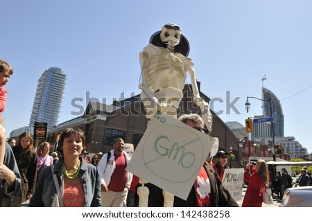 TORONTO-MAY 25: Protestors carrying a skeleton to show the effect of Genetically Modified foods during a rally  against GMO giant Monsanto on May 25, 2013 in Toronto, Canada.