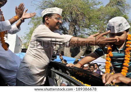AMETHI - APRIL 20:  A rvind Kejriwal garlanding a young boy during a road show in support of Amethi candidate Dr. Kumar Viswas on April 20, 2014 in Amethi ,India.