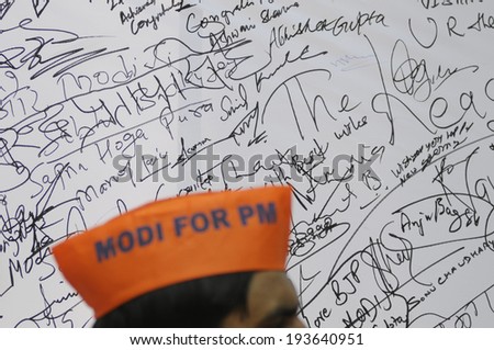 NEW DELHI-MAY 16:  A BJP supporter wearing a saffron cap in front of a message board to write best wishes for Mr. Modi after wining the Indian National election on May 16, 2014 in New Delhi , India.