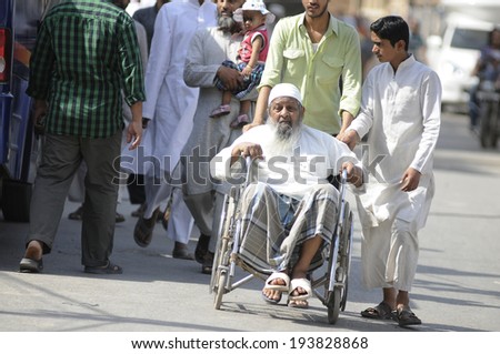 VARANASI - MAY 12:  An old muslim man being carried out of the polling booth after he voted  in the Indian National election on May 12, 2014 in New Delhi , India.