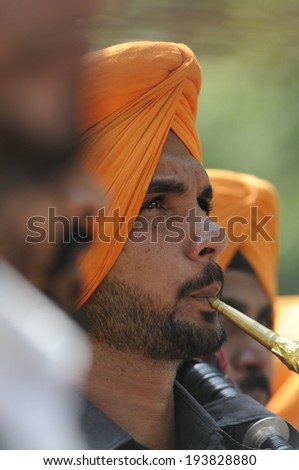 NEW DELHI-MAY 16:  A punjabi band member playing trumpet  to entertain the supporters  after  BJP won the Indian National election on May 16, 2014 in New Delhi , India.
