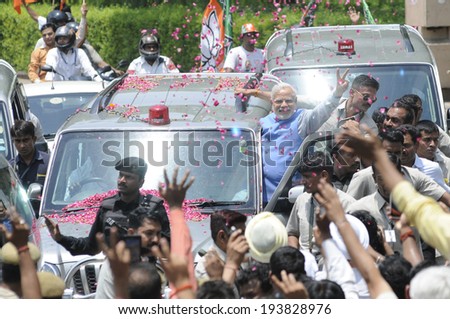 NEW DELHI-MAY 17: Indian Prime Minister Narendra Modi waiving towards the crowd while hanging onto his car after wining the Indian National election on May 17, 2014 in New Delhi , India.
