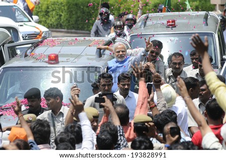 NEW DELHI-MAY 17: Indian Prime Minister  Narendra Modi waiving towards the crowd during a roadshow  after wining the Indian National election on May 17, 2014 in New Delhi , India.