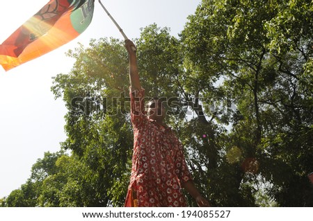 NEW DELHI-MAY 16:  A BJP supporter  waiving BJP flag in front of the party Headquarter  after BJP won  the Indian National election on May 16, 2014 in New Delhi , India.
