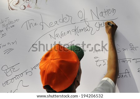 NEW DELHI-MAY 16:  A supporter writing messages on a message board after BJP won  the Indian National election on May 16, 2014 in New Delhi , India.