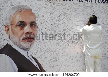 NEW DELHI-MAY 16:  A BJP supporter  writing a message on a message board to write best wishes for Mr. Modi after wining the Indian National election on May 16, 2014 in New Delhi , India.