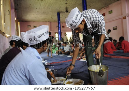VARANASI - MAY  4 : AAP volunteers eating and serving food  during a political meeting on May 4 , 2014 in Varanasi , India.