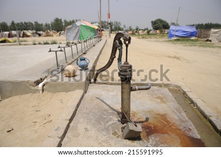 A Mark II human-powered pump designed to lift water from a depth  in front of a tent city in India.