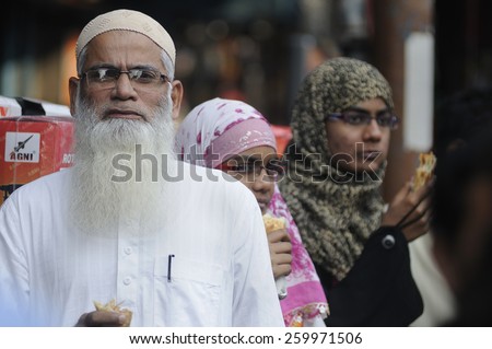 KOLKATA - NOVEMBER 15 : A muslim man along with two muslim women standing on the sidewalk during a rally to celebrate the International Men\'s Day on November 15, 2014 in Kolkata, India.