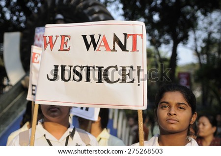 KOLKATA - MARCH 16:School Girls in their uniforms holding signs to seek justice  during a candle light vigil to protest gang rape of an elderly nun on March 16, 2015, at Allen Park in Kolkata, India.