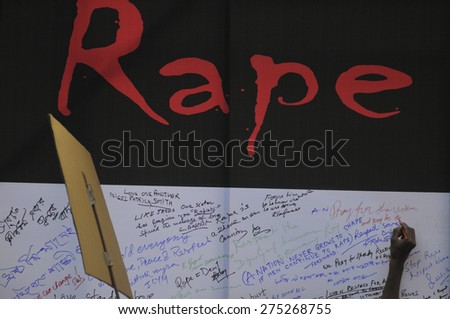 KOLKATA - MARCH 16 : A man writing a message on a message board during a candle light vigil to protest gang rape of an elderly nun on March 16, 2015, at Allen Park in Kolkata, India.