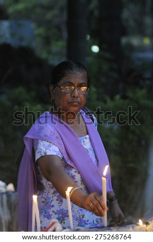 KOLKATA - MARCH 16 : A women lighting candles during a candle light vigil to protest gang rape of an elderly nun on March 16, 2015, at Allen Park in Kolkata, India.