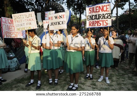 KOLKATA - MARCH 16 : School kids holding signs and banners in solidarity during a candle light vigil to protest gang rape of an elderly nun on March 16, 2015, at Allen Park in Kolkata, India.