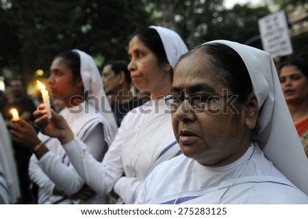 KOLKATA - MARCH 16 : Christian Nuns praying with lighted candles during a candle light vigil to protest gang rape of an elderly nun on March 16, 2015 at Allen Park in Kolkata, India.
