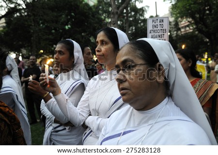KOLKATA - MARCH 16 : Christian Nuns praying with lighted candles during a candle light vigil to protest gang rape of an elderly nun near Ranaghat on March 16, 2015 at Allen Park in Kolkata, India.