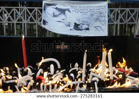 KOLKATA - MARCH 16 : People lighted candles in front of an image of Mother Teresa during a candle light vigil to protest gang rape of an elderly nun on March 16, 2015 at Allen Park in Kolkata, India.