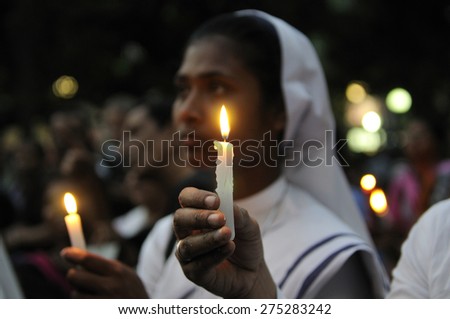 KOLKATA - MARCH 16 : A Christian Nun holding a candle during a candle light vigil to protest gang rape of an elderly nun near Ranaghat on March 16, 2015 at Allen Park in Kolkata, India.