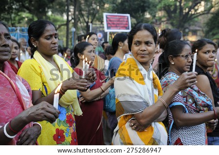 KOLKATA - MARCH 16 :  Women praying with lighted candles during a candle light vigil to protest gang rape of an elderly nun on March 16, 2015 at Allen Park in Kolkata, India.