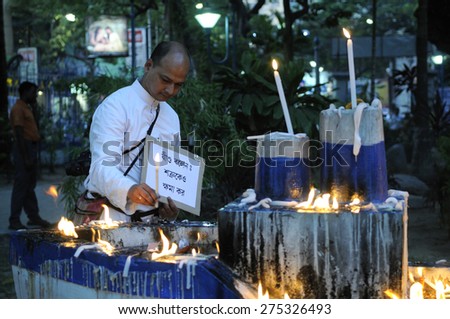 KOLKATA - MARCH 16 : A  priest lighting candles with a sign asking for forgiveness during a candle light vigil to protest gang rape of an elderly nun on March 16, 2015 at Allen Park in Kolkata, India.