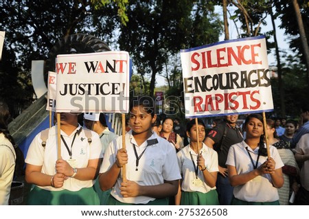 KOLKATA - MARCH 16 : School girls in uniform holding signs asking for justice during a candle light vigil to protest gang rape of an elderly nun on March 16, 2015 at Allen Park in Kolkata, India.