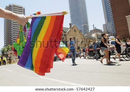 TORONTO-JULY 03:  A vendor holding  different sizes of Rainbow (Gay Pride) Flags and whistles during the Dyke March on  July 03, 2010  in Toronto.