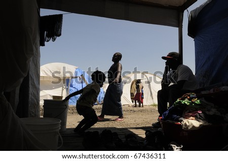 PORT-AU-PRINCE - AUGUST 28:  A woman carrying water for her daily needs as seen from inside a tent, in Port-Au-Prince, Haiti on August 28, 2010.