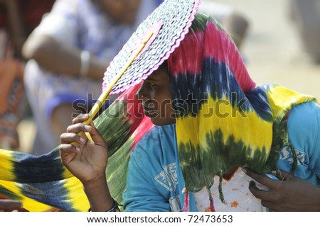 KOLKATA- FEBRUARY 13:  A woman supporter cooling herself with a \
