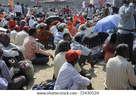 KOLKATA- FEBRUARY 13:   People with umbrellas and handkerchiefs to protect themselves from the heat during a political rally  in Kolkata, India on February 13, 2011.
