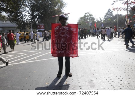 KOLKATA- FEBRUARY 13:  A supporter showing off his banner which praises the  present Chief Minister -Mr.Buddhadeb Bhattacharjee  during a political rally  in Kolkata, India on February 13, 2011.