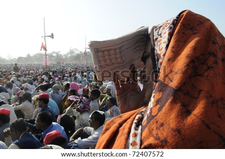 KOLKATA- FEBRUARY 13: A woman shields herself from the scorching  heat during a political rally in Kolkata, India on February 13, 2011.