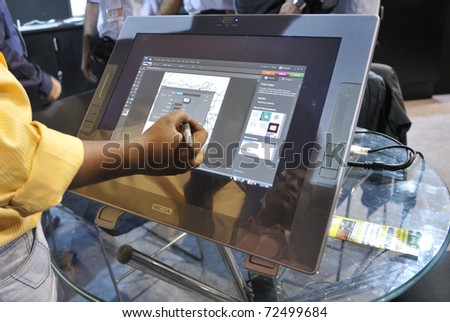 KOLKATA- FEBRUARY 20: A visitor  draws on a screen with a cordless touch pen during the Information and Communication Technology (ICT) conference and exhibition in Kolkata, India on February 20,2011.
