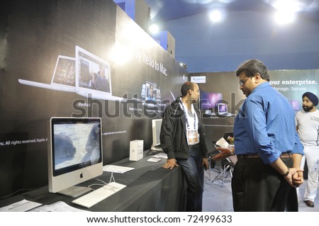 KOLKATA- FEBRUARY 20:  Visitors looking at a movie on a MAC computer, during the Information and Communication Technology (ICT) conference and exhibition in Kolkata, India on February 20, 2011.