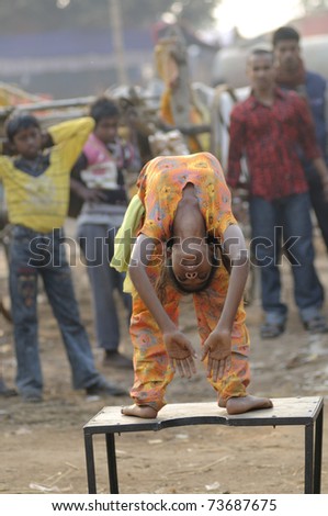 KENDULI - JANUARY 14: A poor unidentified kid performing acrobatics on the streets-a very common practice for the poor families - to earn a living for her family ,in Kenduli ,India on January 14, 2011.