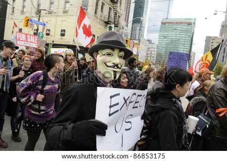 TORONTO - OCTOBER 17: Protestor wearing a guy fawkes masks walking in a rally  during the Occupy Toronto Movement on October 17, 2011 in Toronto, Canada.