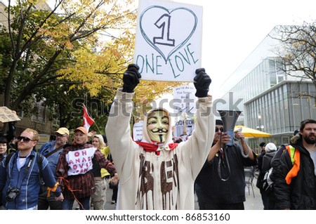 TORONTO - OCTOBER 17: A protestor wearing a guy fawkes mask walking in a rally  during the Occupy Toronto Movement on October 17, 2011 in Toronto, Canada.
