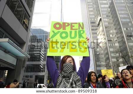 TORONTO - NOVEMBER 24:  A protester holding a placard that asks the people to open their eyes and join the movement during a rally on November 24, 2011 in Toronto, Canada.