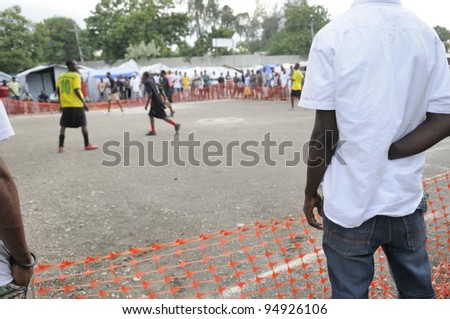 PORT-AU-PRINCE - AUGUST 26:  An handicapped man watching a friendly soccer game in a small ground within a tent city in Port-Au-Prince, Haiti on August 26, 2010.