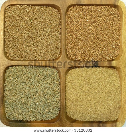 assorted grains (wheat, rye, bulgur and buckwheat) in a wooden square container