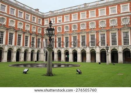 LONDON, ENGLAND - JUNE 14, 2014: Courtyard of Hampton Court Palace on June 14, 2014 in London, England. It is one of the most visited palaces in England.