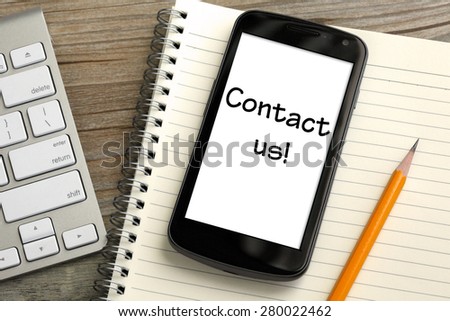 concept of Call Us now, with mobile phone and desk background