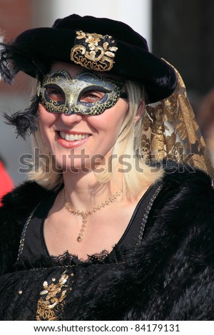 VENICE, ITALY - FEBRUARY 26: Masked lady in medieval costume greet visitors at the annual Venice Carnival festival on February 26, 2011 in Venice, Italy.