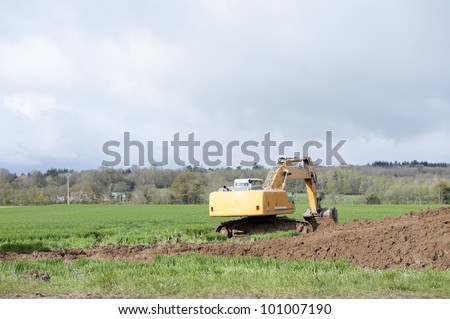 earth-mover dumping earth on a hill