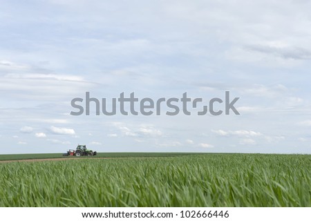 tractor working in the fields against a blue sky