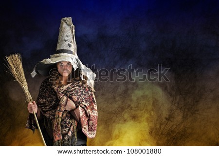 halloween witch with hat and broom, smoke and fire background
