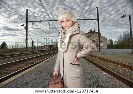 young woman in winter clothes waiting for her train