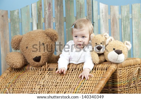 toddler with teddy bears standing in a straw trunk